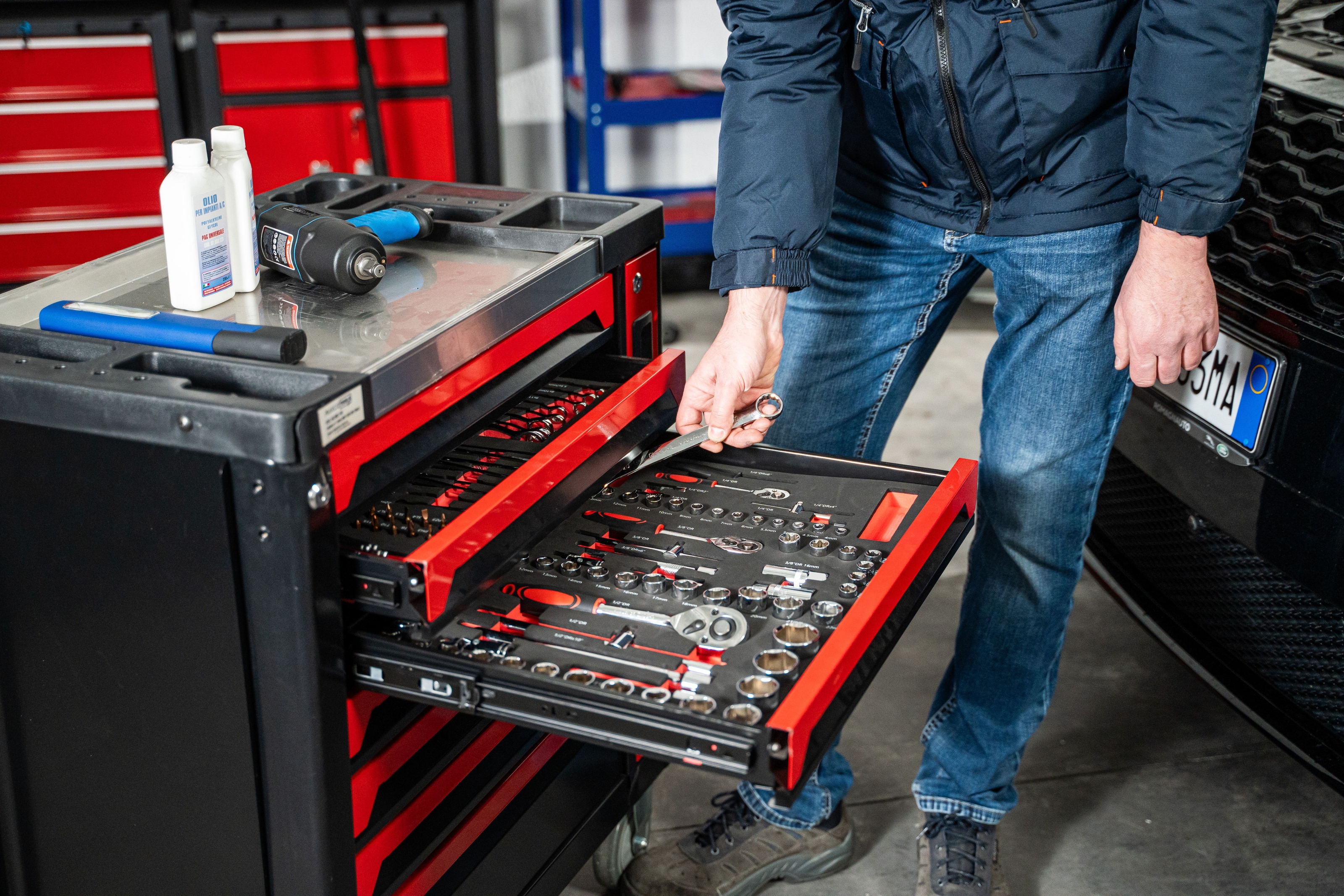 Tecnico al lavoro con utensili professionali su un carrello da officina Spin